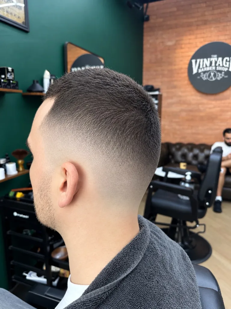 Back and side view of a short textured haircut with a skin fade at the neckline and around the ear