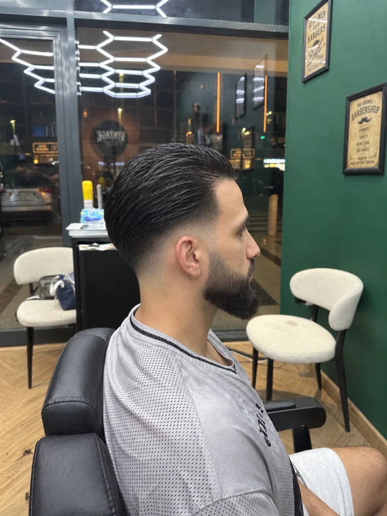 The same swept-back haircut from the other side, showing the fade dropping towards the nape
